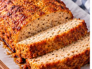 Baked free-form chicken meatloaf with slices showing the interior.